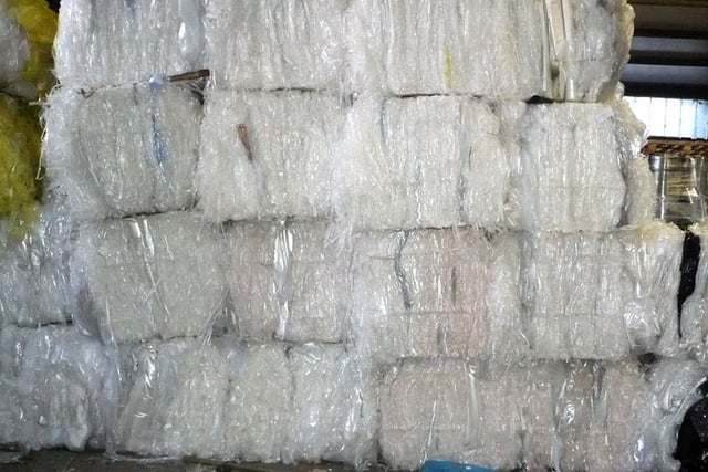 a large pile of white plastic bags in a warehouse